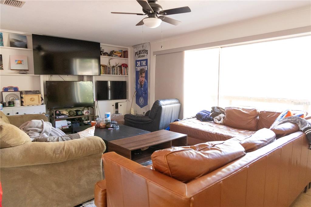 2910 Southwest 1st Avenue Gainesville, FL 32607 - Photo 12 of 16 a living room with furniture a flat screen tv and a window