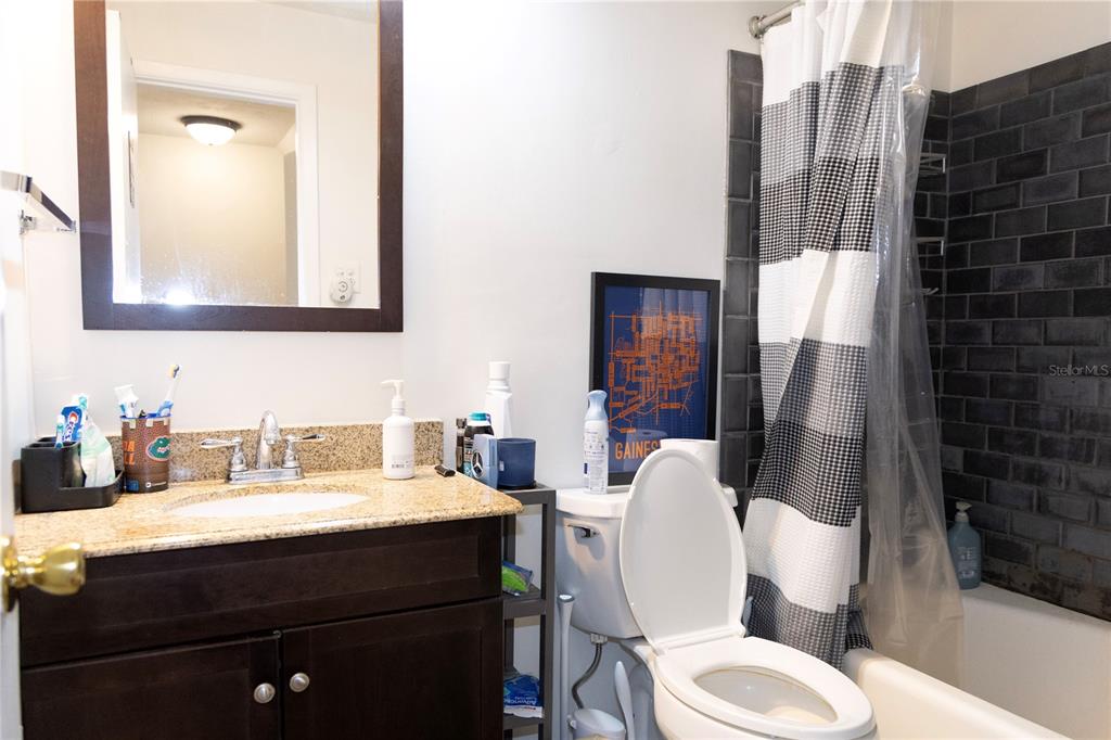 2910 Southwest 1st Avenue Gainesville, FL 32607 - Photo 16 of 16 a bathroom with a sink a toilet a mirror and shower