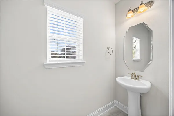 a bathroom with a sink a mirror and a window