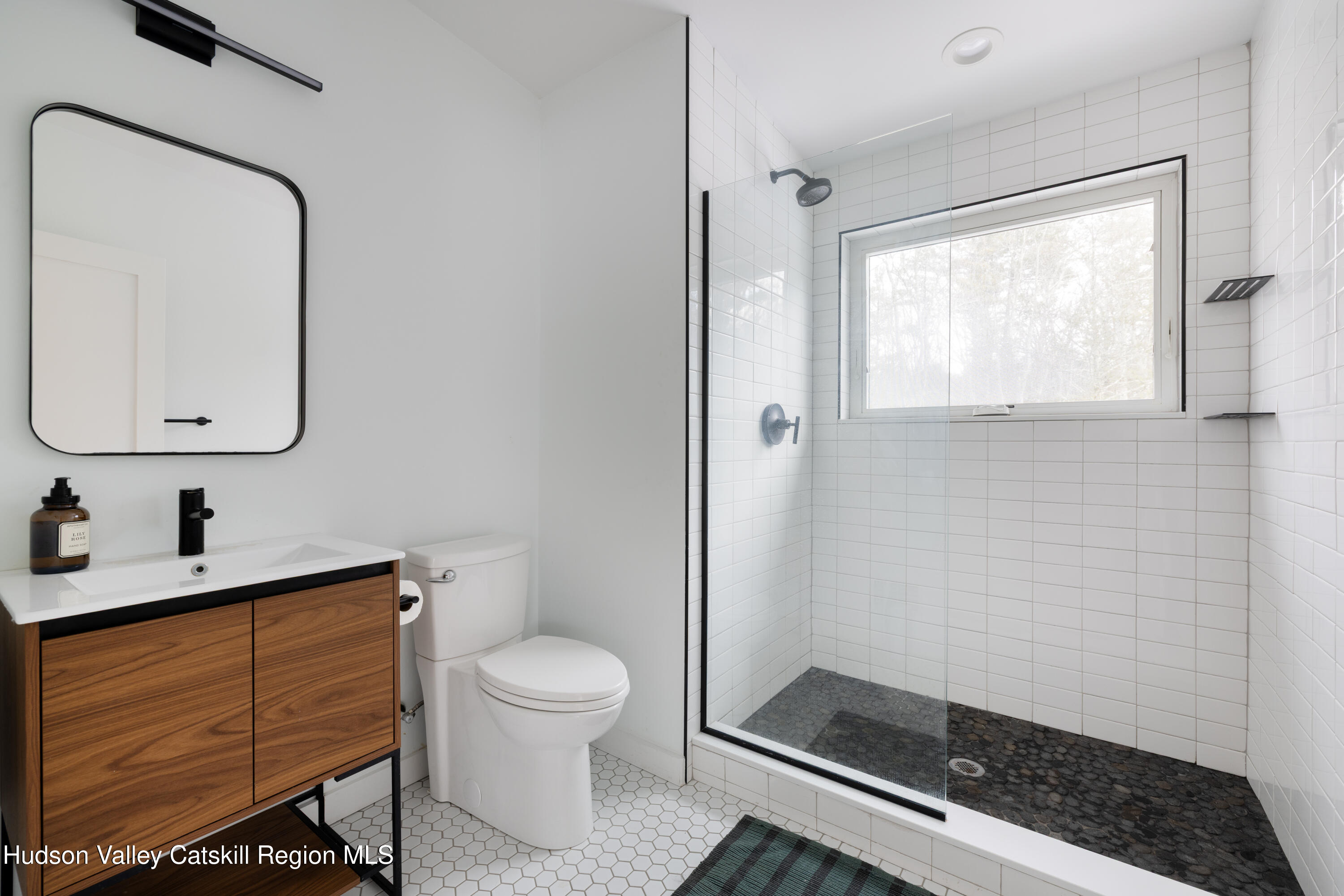 158 Rivka Road Saugerties, NY 12477 - Photo 16 of 35 a bathroom with a sink a toilet a mirror and shower