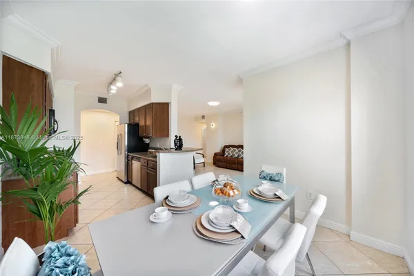 a living room with furniture kitchen and a potted plant