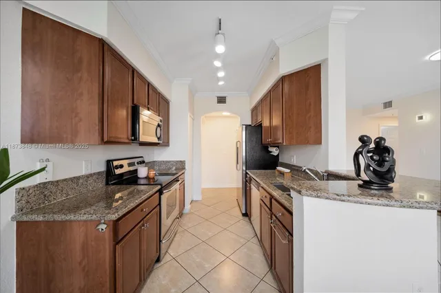 a kitchen with granite countertop a sink a stove and a refrigerator