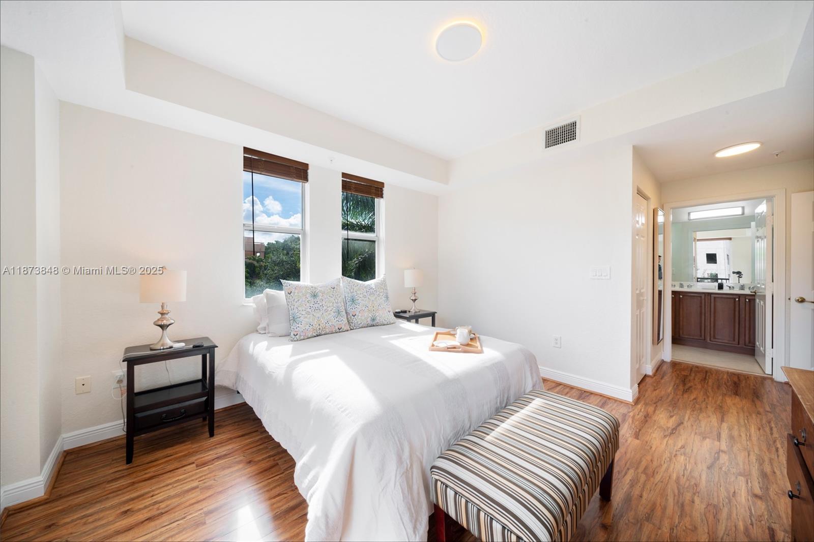 9021 Southwest 94th Street, Unit 310 Miami, FL 33176 - Photo 19 of 41 a bedroom with a bed and a view of bathroom