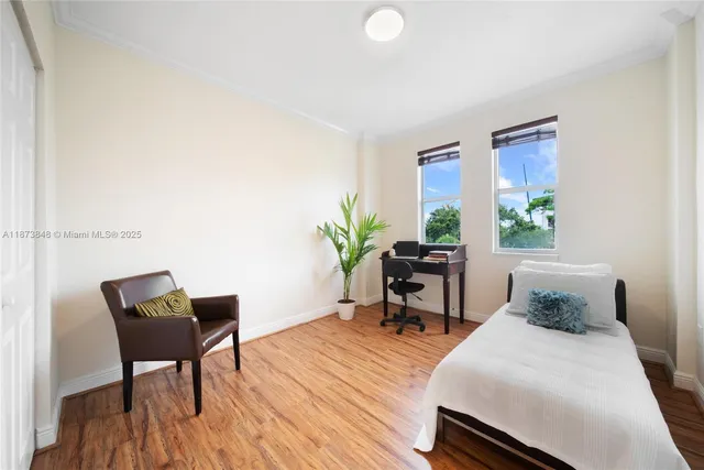 a living room with furniture and a potted plant next to a window