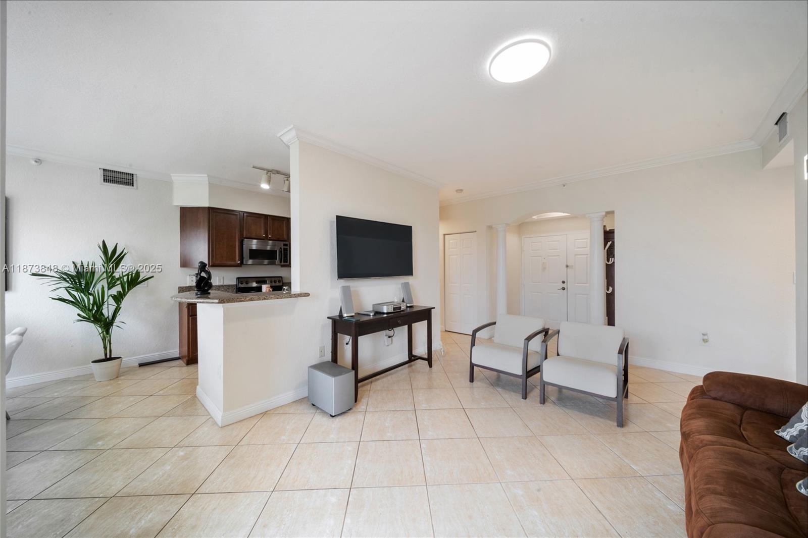 9021 Southwest 94th Street, Unit 310 Miami, FL 33176 - Photo 5 of 41 a living room with furniture a flat screen tv and kitchen view