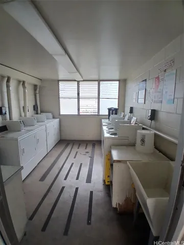 a large kitchen with kitchen island white cabinets and stainless steel appliances