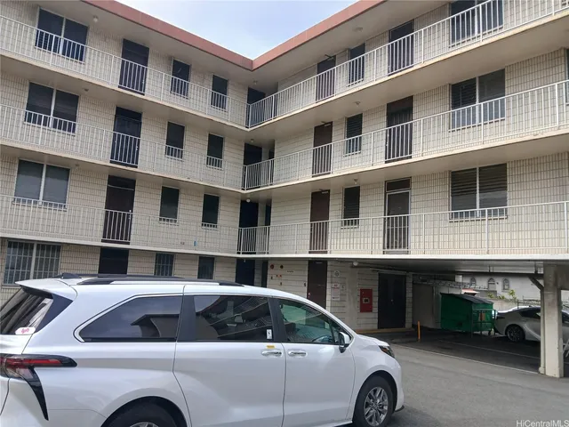 a view of building and car parked in front of house