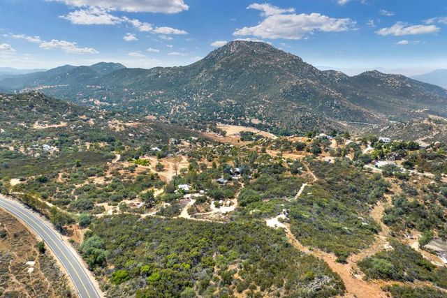 a view of dirt field with trees in the background