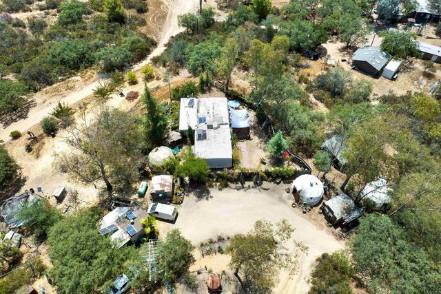 a kitchen with stainless steel appliances kitchen island granite countertop a stove a refrigerator and white cabinets with wooden floors