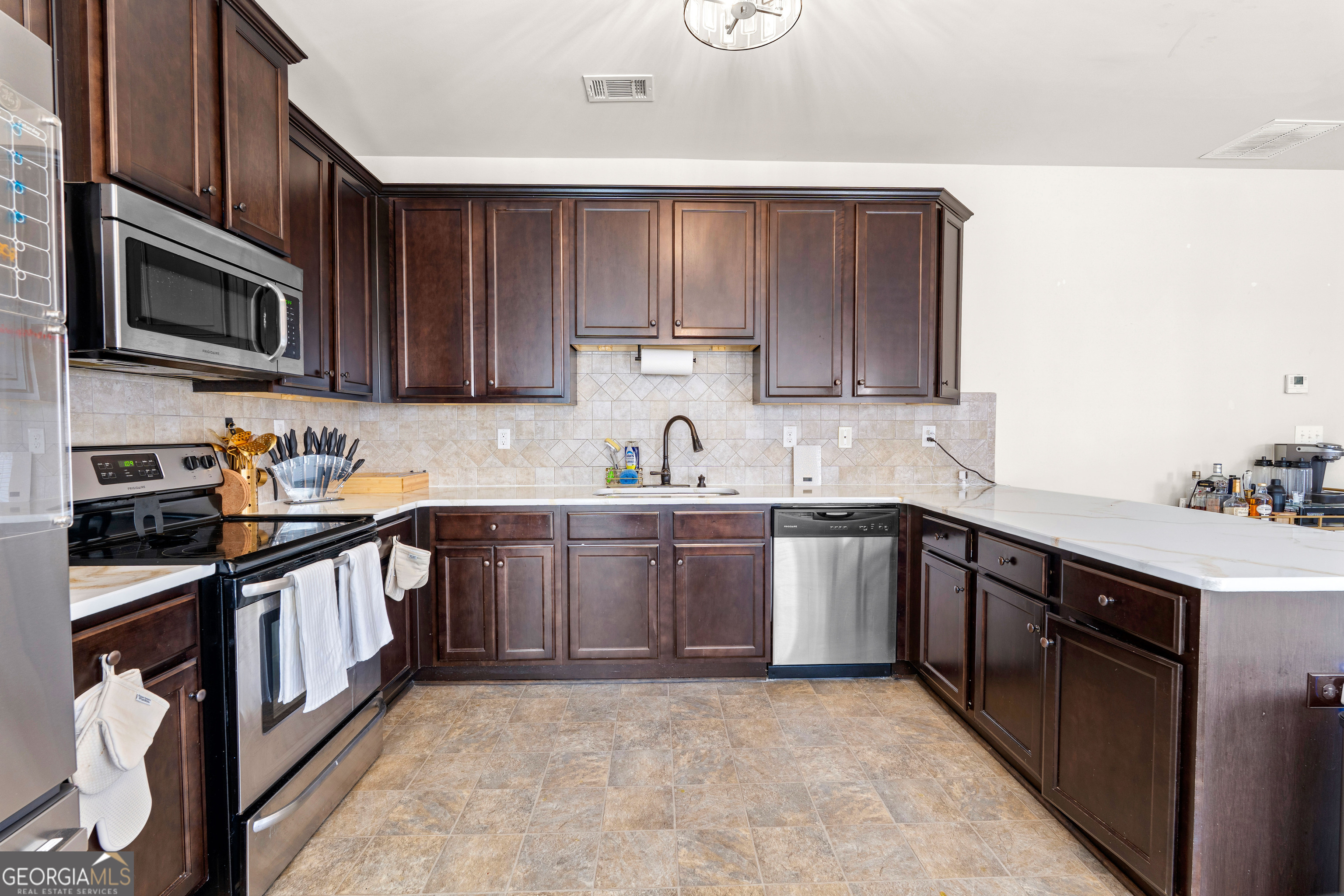 112 Truman Court Jackson, GA 30233 - Photo 14 of 42 a kitchen with stainless steel appliances granite countertop a sink stove and microwave