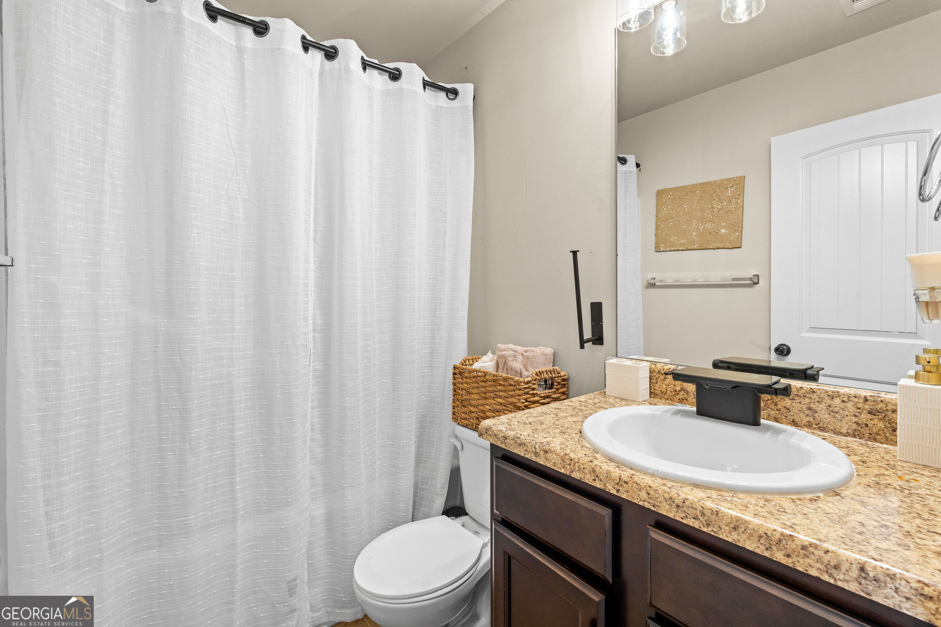 112 Truman Court Jackson, GA 30233 - Photo 24 of 42 a bathroom with a granite countertop sink and a mirror
