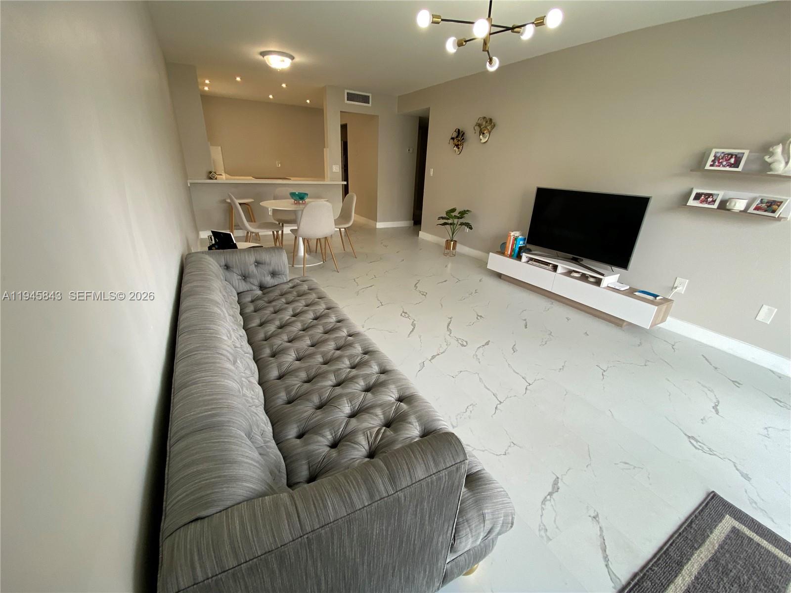 7743 Southwest 86th Street, Unit D129 Miami, FL 33143 - Photo 1 of 17 a living room with furniture and a flat screen tv