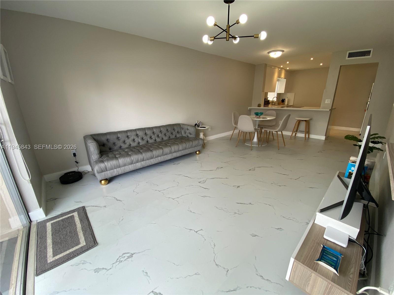 7743 Southwest 86th Street, Unit D129 Miami, FL 33143 - Photo 2 of 17 a living room with furniture and a flat screen tv