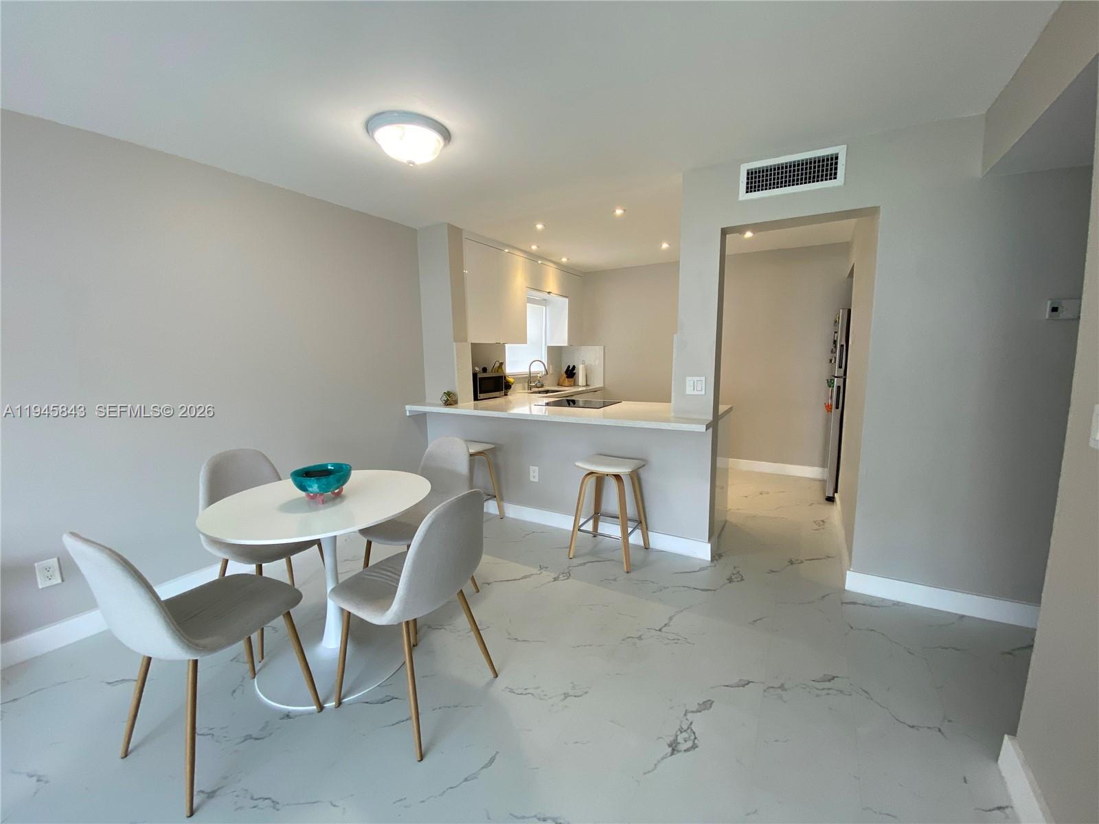 7743 Southwest 86th Street, Unit D129 Miami, FL 33143 - Photo 3 of 17 a view of a dining room with furniture and a chandelier