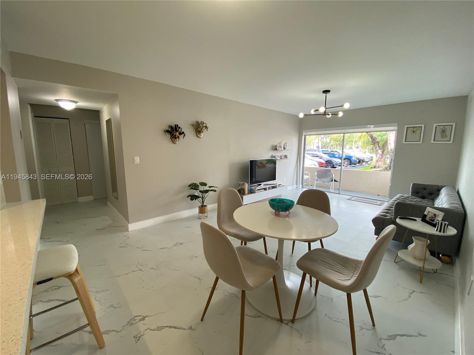 7743 Southwest 86th Street, Unit D129 Miami, FL 33143 - Photo 6 of 17 a view of a dining room with furniture and chandelier