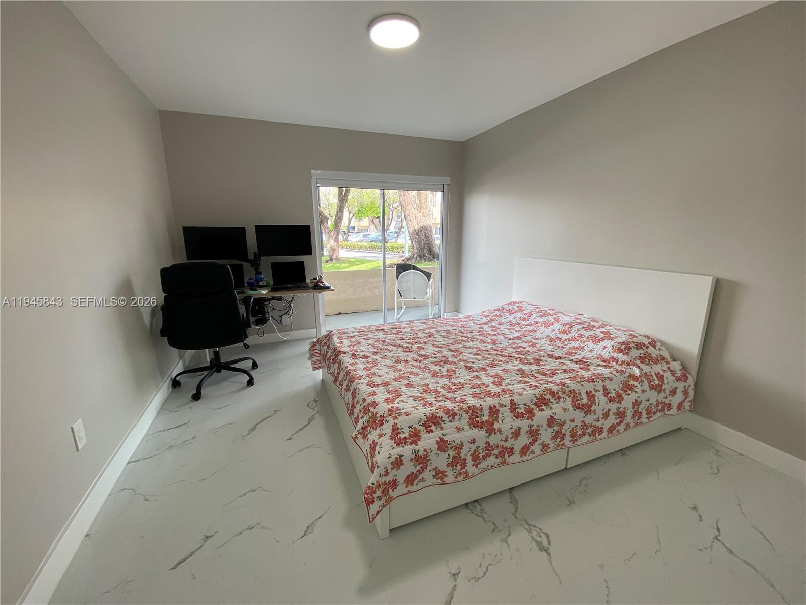 7743 Southwest 86th Street, Unit D129 Miami, FL 33143 - Photo 8 of 17 a bedroom with a bed and glass window