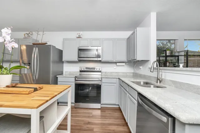 a kitchen with stainless steel appliances a sink dishwasher stove refrigerator and microwave