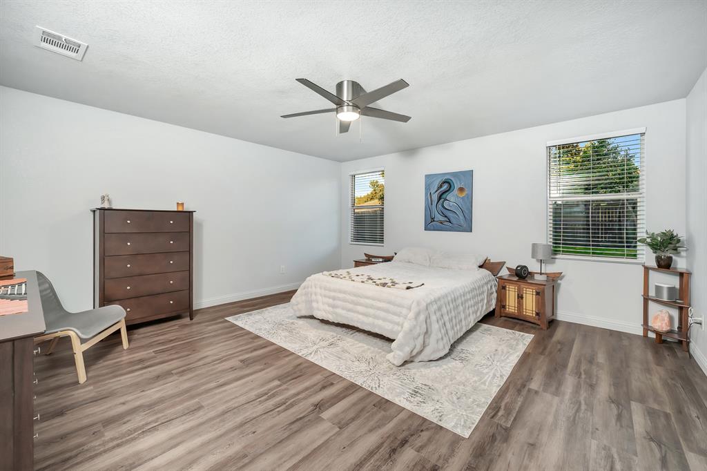 2633 Rockport Lane Little Elm, TX 75068 - Photo 14 of 39 a spacious bedroom with a bed and wooden floor