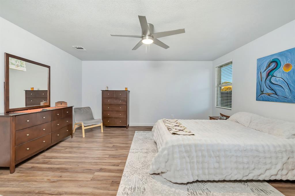 2633 Rockport Lane Little Elm, TX 75068 - Photo 15 of 39 a bedroom with a bed and a dresser