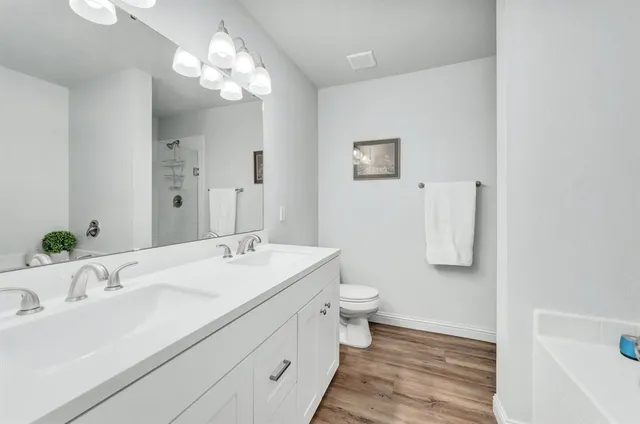 a bathroom with a sink a toilet and a large mirror