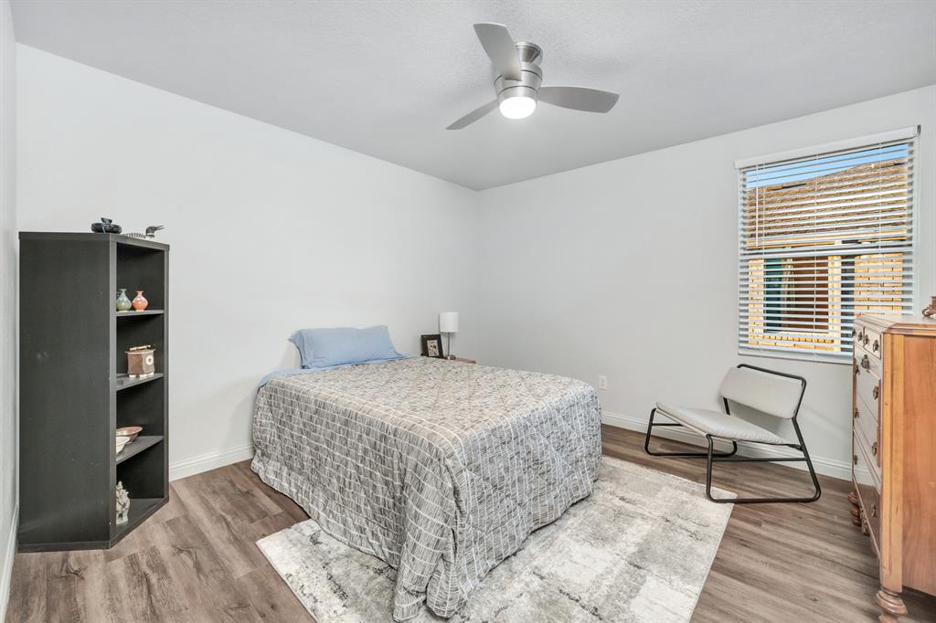 2633 Rockport Lane Little Elm, TX 75068 - Photo 21 of 39 a bedroom with a bed and a chandelier