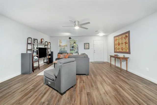 a living room with furniture and a wooden floor