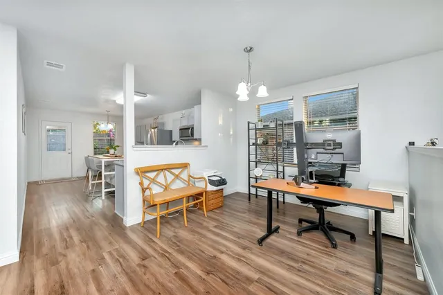 a room with wooden floor table and chairs