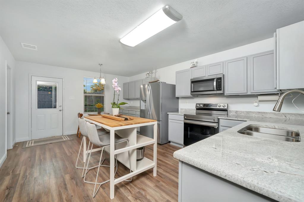 2633 Rockport Lane Little Elm, TX 75068 - Photo 6 of 39 a kitchen with a stove a sink and a refrigerator