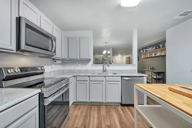 a kitchen with stainless steel appliances a sink stove and microwave