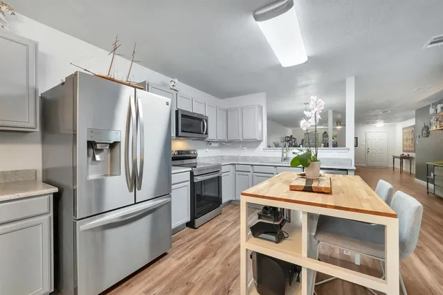 a kitchen with kitchen island a counter appliances and cabinets