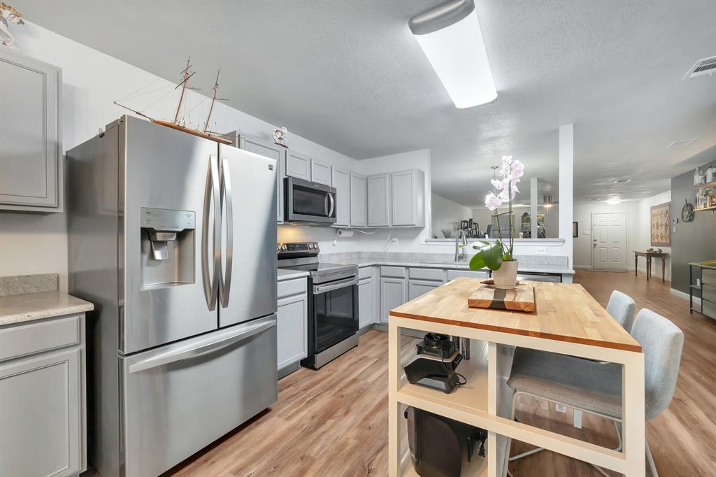 2633 Rockport Lane Little Elm, TX 75068 - Photo 10 of 39 a kitchen with kitchen island a counter appliances and cabinets