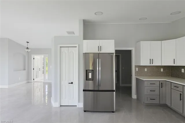 a kitchen with white cabinets sink and stainless steel appliances