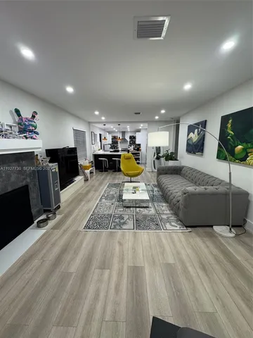 a large kitchen with a large counter top appliances and a wooden floor