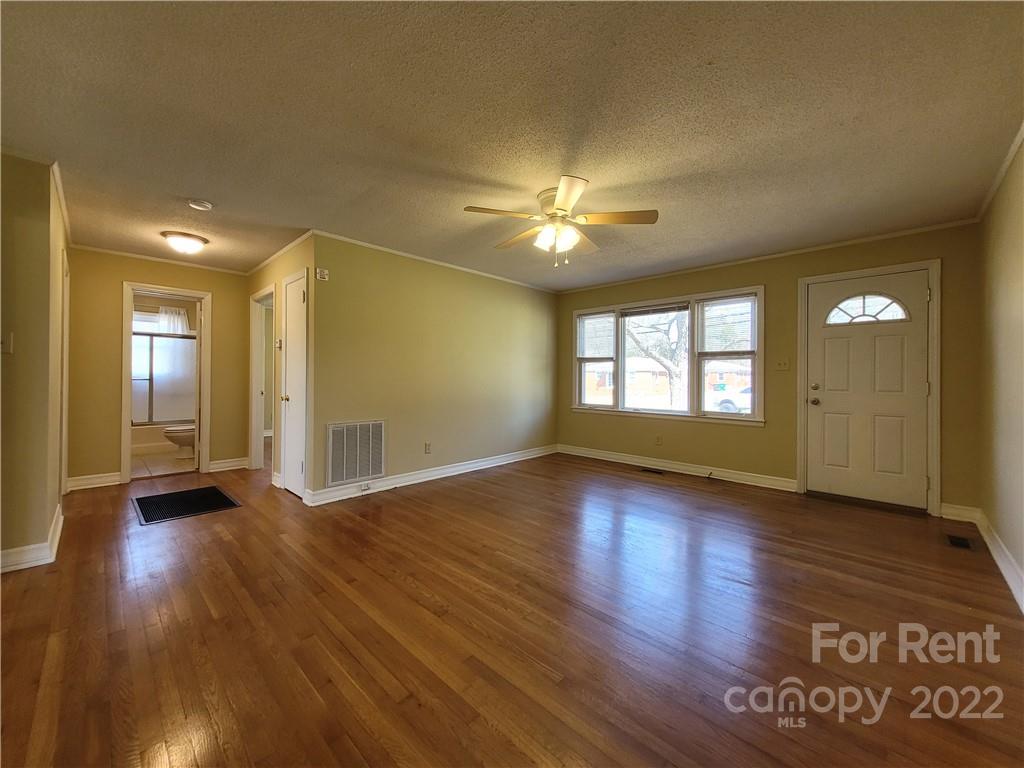 2123 Oakdale Road Charlotte, NC 28216 - Photo 3 of 13 a view of an empty room with window and wooden floor