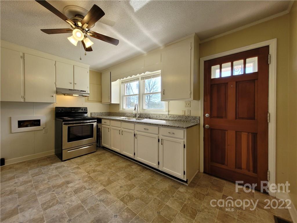 2123 Oakdale Road Charlotte, NC 28216 - Photo 4 of 13 a kitchen with a stove a sink and a refrigerator