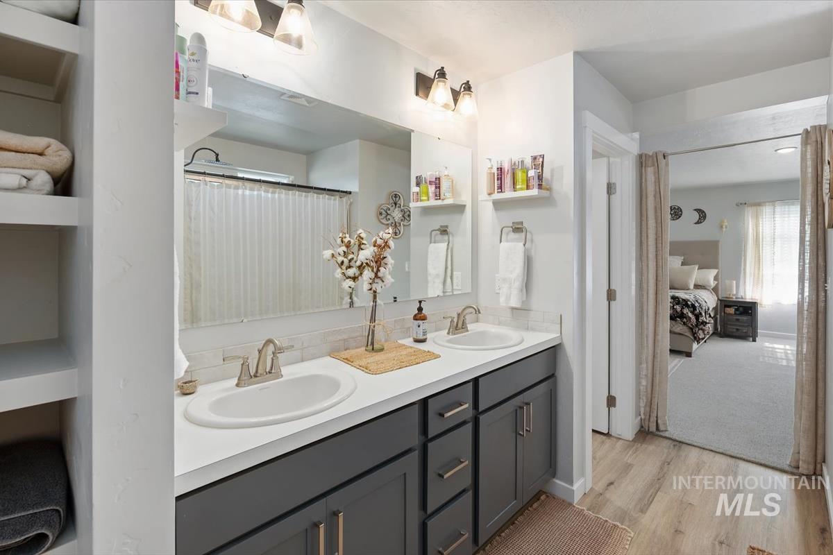 11359 West Langit Street Star, ID 83669 - Photo 14 of 39 Ensuite bathroom with double vanity, a shower with curtain, and light wood finished floors