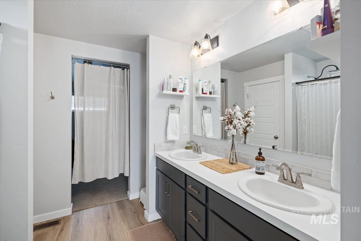 11359 West Langit Street Star, ID 83669 - Photo 15 of 39 Bathroom with double vanity, curtained shower, and light wood-style floors