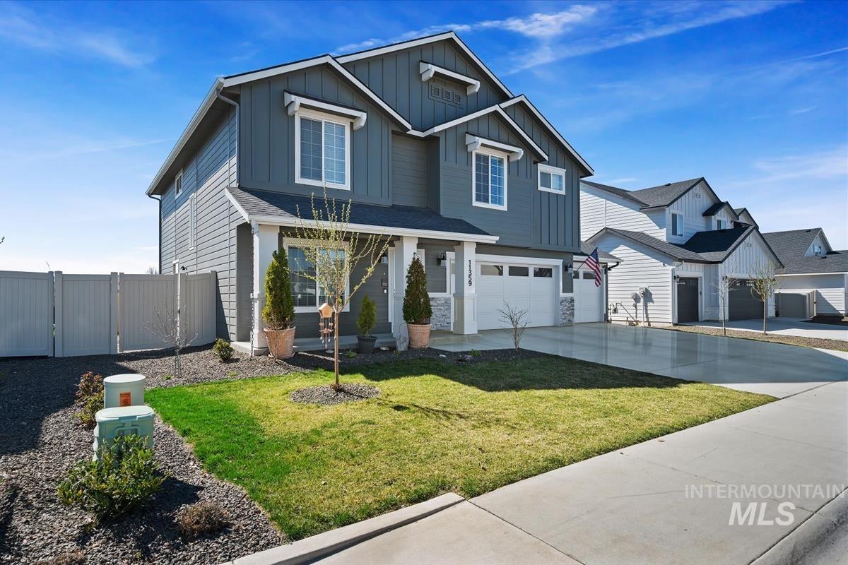 11359 West Langit Street Star, ID 83669 - Photo 33 of 39 View of front facade featuring a gate, an attached garage, driveway, board and batten siding, and stone siding