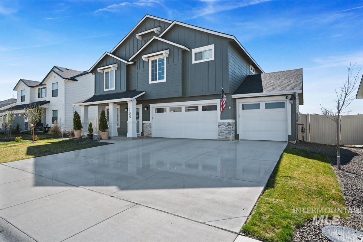 11359 West Langit Street Star, ID 83669 - Photo 34 of 39 View of front of property with concrete driveway, board and batten siding, stone siding, and an attached garage