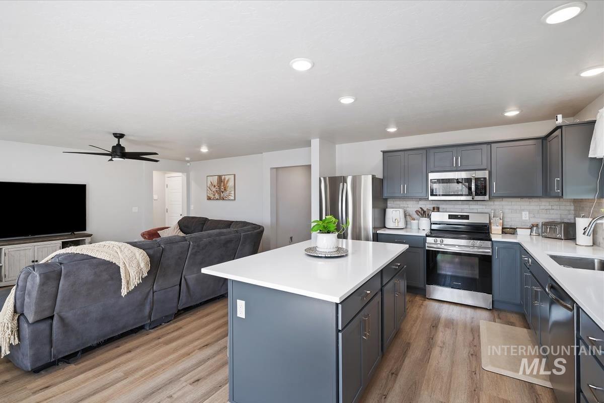 11359 West Langit Street Star, ID 83669 - Photo 38 of 39 Kitchen featuring open floor plan, stainless steel appliances, a center island, ceiling fan, and light wood finished floors