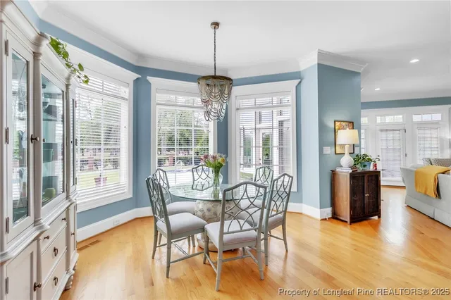 a dining room with furniture a chandelier and wooden floor