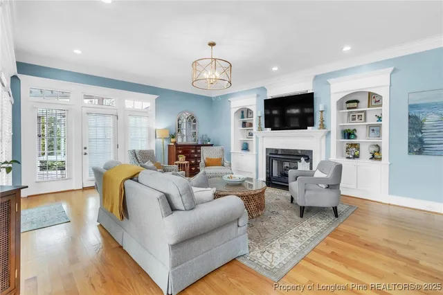 a living room with furniture a flat screen tv and a fireplace