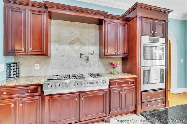 a kitchen with stainless steel appliances granite countertop a stove a sink and a microwave