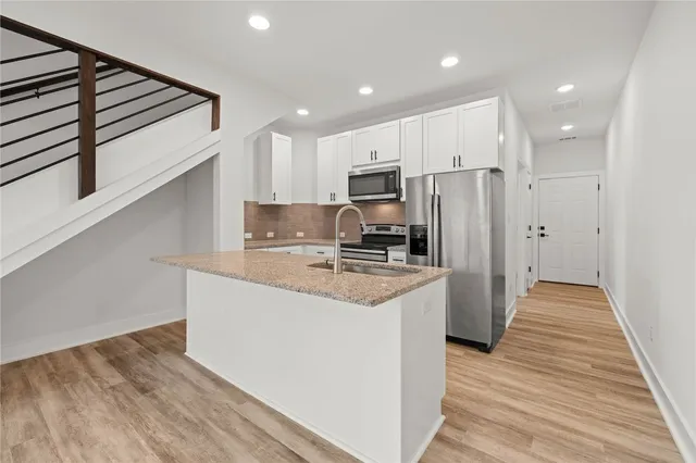 a kitchen with stainless steel appliances a refrigerator and a stove top oven
