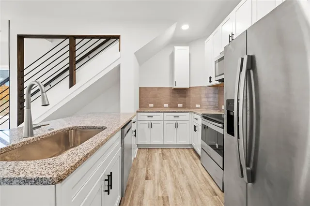a kitchen with a sink a refrigerator and cabinets