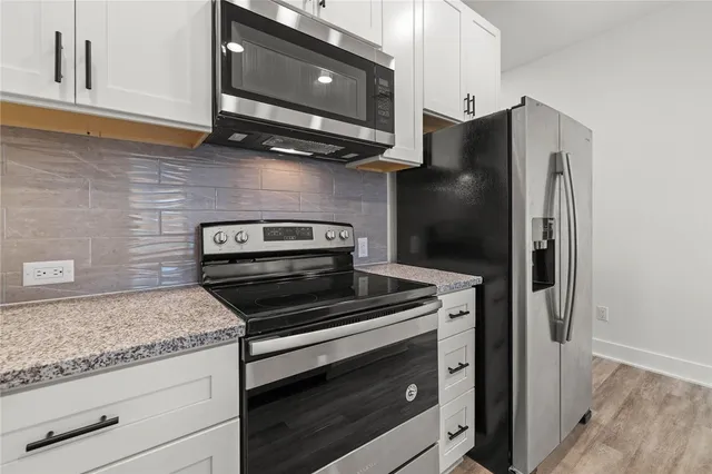 a kitchen with granite countertop cabinets and steel stainless steel appliances