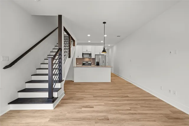 a view of a kitchen with wooden floor and stairs