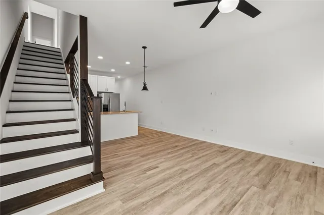 a view of a livingroom with wooden floor and stairs