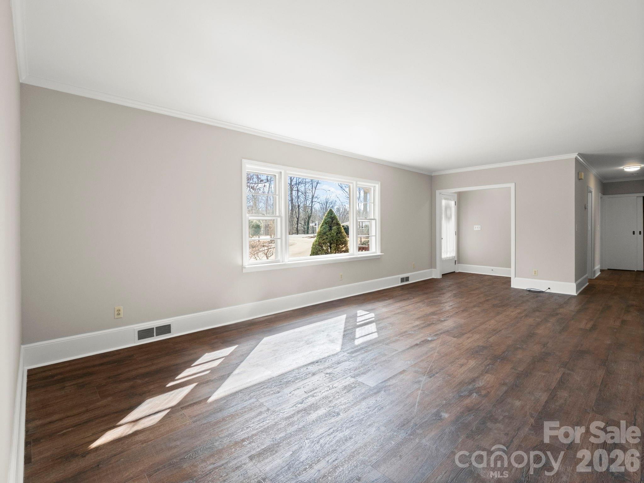 204 West Fernwood Drive Rutherfordton, NC 28139 - Photo 12 of 34 an empty room with wooden floor and windows