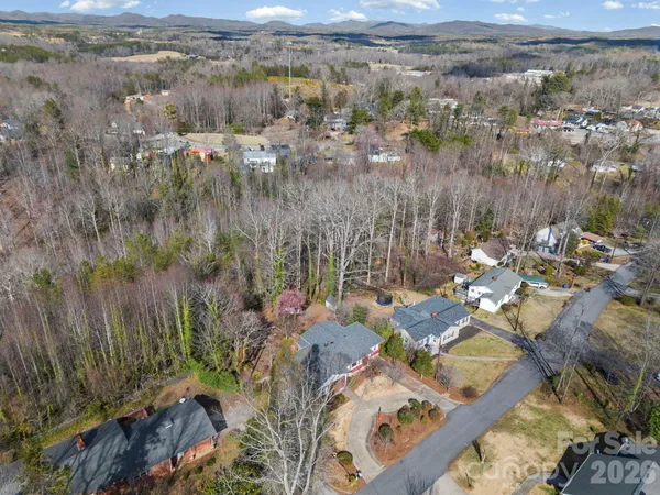 an aerial view of house with yard and ocean view